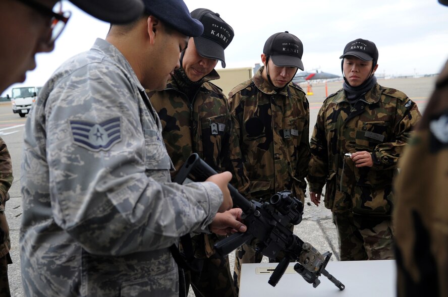 U.S. Air Force Staff Sgt. Francisco Salas, 18th Security Forces Squadron armory NCO in charge, shows members from the Japanese Air Self Defense Force 6th Wing Security Guard Squadron, an M-4 rifle during a security forces demonstration at Komatsu Air Base, Japan, Dec. 11, 2013. As part of a week-long Aviation Training Relocation Program, U.S. and Japanese security members spent time learning and observing how each country performs the same mission. (U.S. Air Force photo by Staff Sgt. Amber E. N. Jacobs)