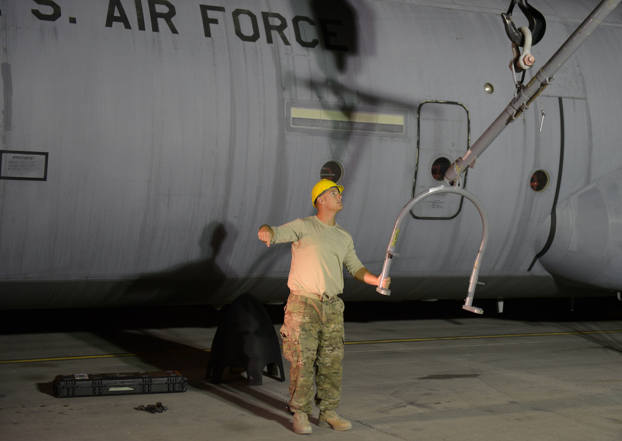 Staff Sgt. Andrew McConkay gives commands to Staff Sgt. Daniel Fox, 557th Expeditionary Red Horse Squadron heavy equipment operators, as he operates a crane after an engine swap by members of the 379th Expeditionary Aircraft Maintenance Squadron, 746th Expeditionary Aircraft Maintenance Unit propulsion at the 379th Air Expeditionary Wing, Southwest Asia, Dec. 11, 2013. The 557th ERHS provided short notice support for the engine swap by supplying the crane and personnel to hoist the engine out and install the new engine. The combined efforts contributed to the engine being swapped in 12 hours and the aircraft ready to fly on schedule. McConkay is deployed from Nellis Air Force Base, Nev., and a Salt Lake City native. (U.S. Air Force photo/Master Sgt. David Miller)