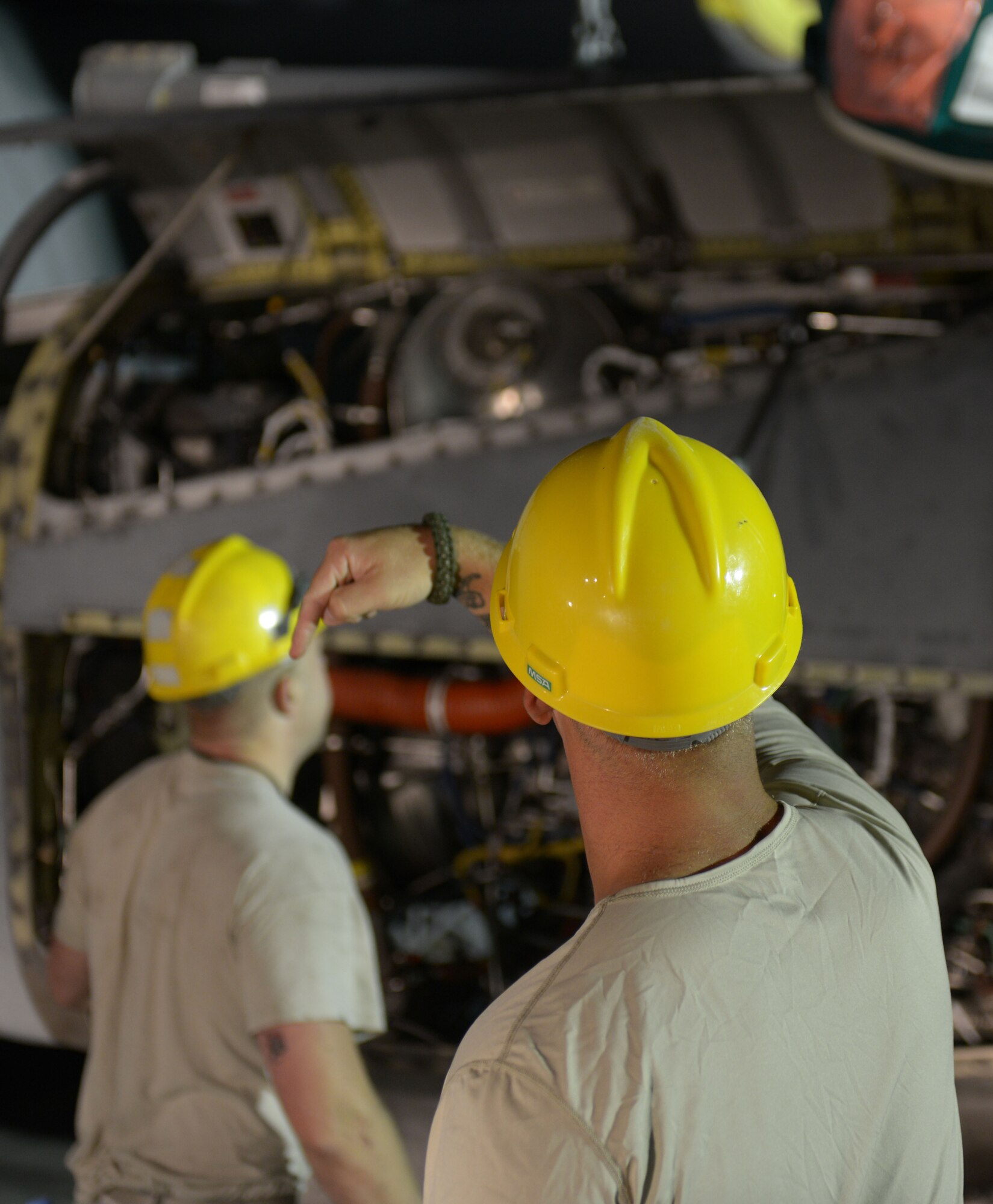 Staff Sgt. Andrew McConkay gives commands to Staff Sgt. Daniel Fox, 557th Expeditionary Red Horse Squadron heavy equipment operators as he operates a crane during a C-130 engine swap by members of the 379th Expeditionary Aircraft Maintenance Squadron, 746th Expeditionary Aircraft Maintenance Unit propulsion flight, at the 379th Air Expeditionary Wing, Southwest Asia, Dec. 11, 2013. The 557th ERHS provided short notice support for the engine swap by supplying the crane and personnel to hoist the engine out and install the new engine. The combined efforts contributed to the engine being swapped in 12 hours and the aircraft ready to fly on schedule. McConkay is deployed from Nellis Air Force Base, Nev., and a Salt Lake City native. (U.S. Air Force photo/Master Sgt. David Miller)