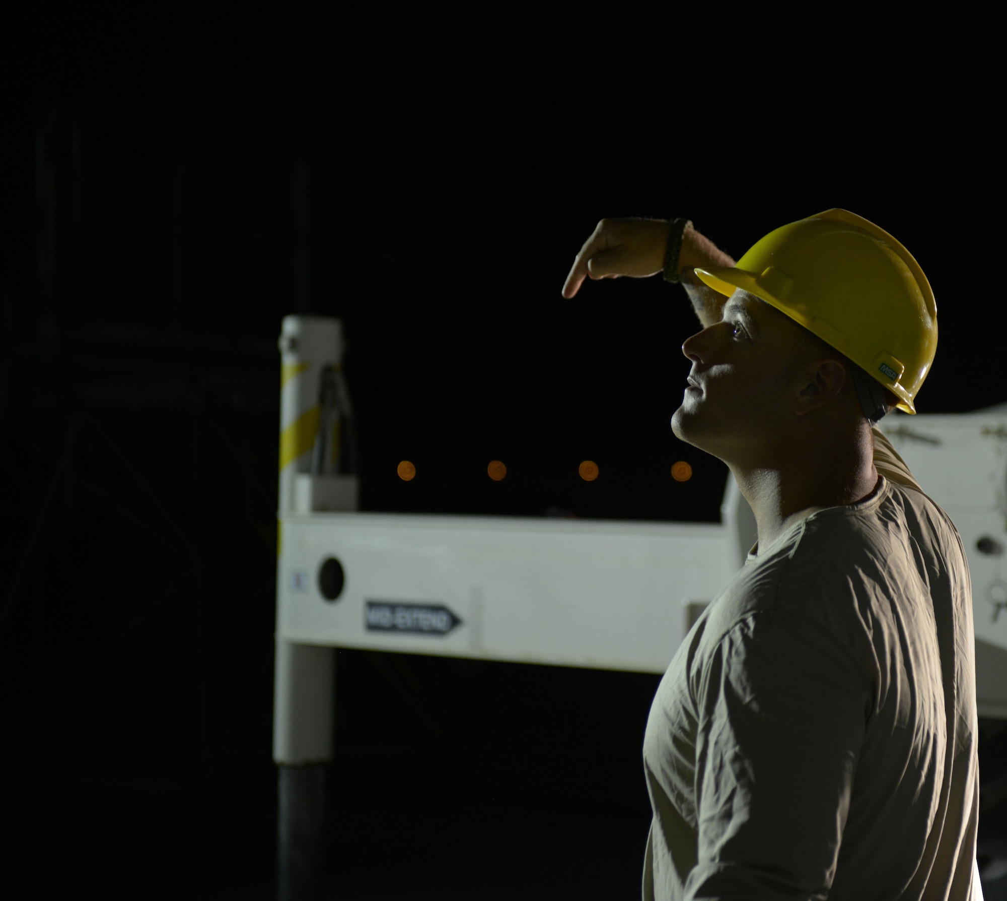 Staff Sgt. Andrew McConkay gives commands to Staff Sgt. Daniel Fox, 557th Expeditionary Red Horse Squadron heavy equipment operators as he operates a crane during a C-130 engine swap by members of the 379th Expeditionary Aircraft Maintenance Squadron, 746th Expeditionary Aircraft Maintenance Unit propulsion flight, at the 379th Air Expeditionary Wing, Southwest Asia, Dec. 11, 2013. The 557th ERHS provided short notice support for the engine swap by supplying the crane and personnel to hoist the engine out and install the new engine. The combined efforts contributed to the engine being swapped in 12 hours and the aircraft ready to fly on schedule. McConkay is deployed from Nellis Air Force Base, Nev., and a Salt Lake City native. (U.S. Air Force photo/Master Sgt. David Miller)