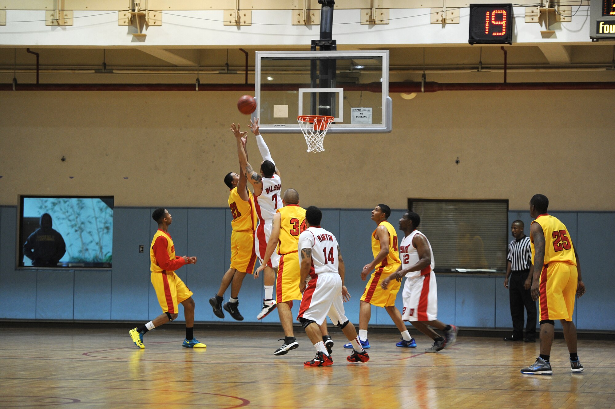 Osan and Suwon basketball team members reach for and attempt to recover the rebound during the Pacific Holiday Basketball Tournament at Osan Air Base, Republic of Korea, Dec. 12, 2013. Teams from Anderson Air Force Base, Guam,  Kadena AB, Japan, and other bases on the Korean peninsula participated in the annual tournament.  (U.S. Air Force photo/Staff Sgt. Emerson Nuñez)