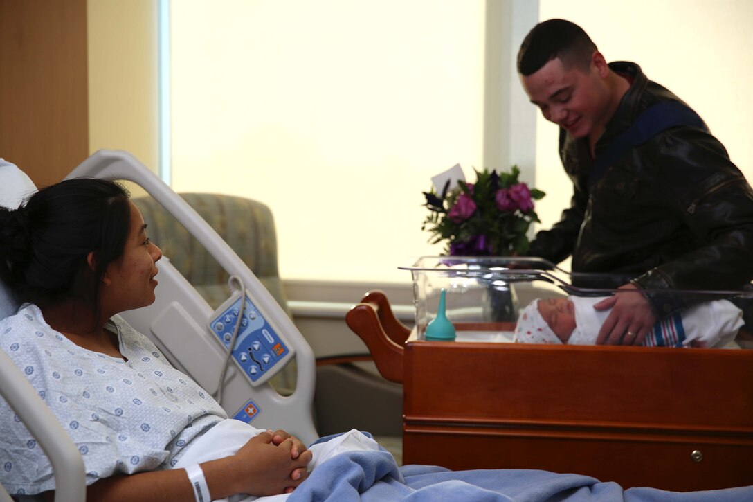 One of the first patients at Camp Pendleton’s newest hospital, Lance Cpl. Lucia Y. Cabral, watches her husband, Pfc. Nicholas M. Cabral, marvel at their newborn baby. The Naval Hospital Camp Pendleton facility, built in 1969, was officially decommissioned, requiring patients to be relocated to Pendleton’s recently built, 500,000-square foot, replacement hospital Dec. 14. The four-floor building cost $456 million and took more than three years to construct. Lucia is a maintenance management specialist and Nicholas is a warehouse clerk with1st Marine Logistics Group.