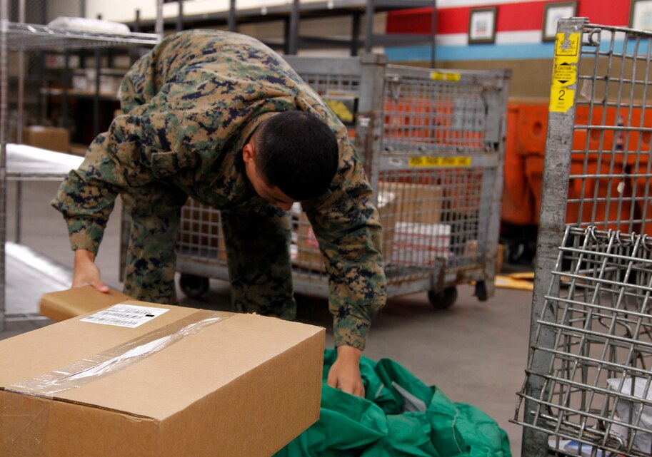 Lance Cpl. Basem Bakhtan, postal clerk, Headquarters Battalion, sorts through incoming mail at the Combat Center Post Office Dec. 11. During the holiday season, postal Marines work twice as hard to make sure service members and their families receive their holiday packages.