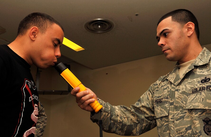 U.S. Air Force Staff Sgt. Jose Perez, 18th Security Forces Squadron security force leader, uses a portable breathalyzer to check the alcohol levels of Airman 1st Class Aaron Norris, 718th Aircraft Maintenance Squadron electronic environmental apprentice, after a few hours of drinking during the Drunk Driving Awareness training on Kadena Air Base, Dec. 13, 2013. During the training, 10 individuals consumed alcohol in a supervised and controlled environment before conducting field sobriety tests to show the effects of certain alcohol levels. (U.S. Air Force photo by Naoto Anazawa)