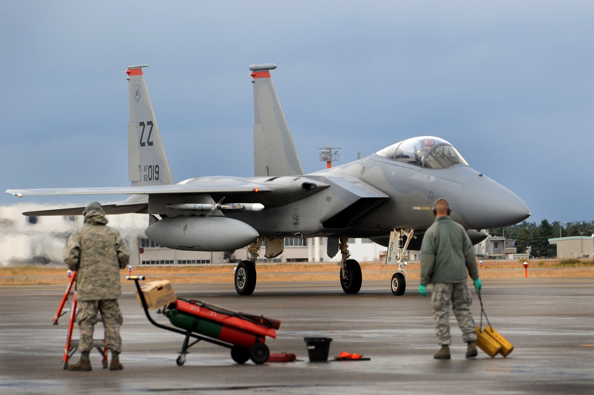 U.S. Air Force 67th Fighter Squadron crew chiefs stand ready to assist an F-15 Eagle as it prepares to park on Komatsu Air Base, Japan, Dec. 7, 2013. The 67th FS participated in a week-long bilateral Aviation Training Relocation Program with the Japanese Air Self Defense Force 6th Wing. The program emphasizes interoperability training between U.S. and Japanese forces while promoting operational readiness. (U.S. Air Force photo by Staff Sgt. Amber E. N. Jacobs)
