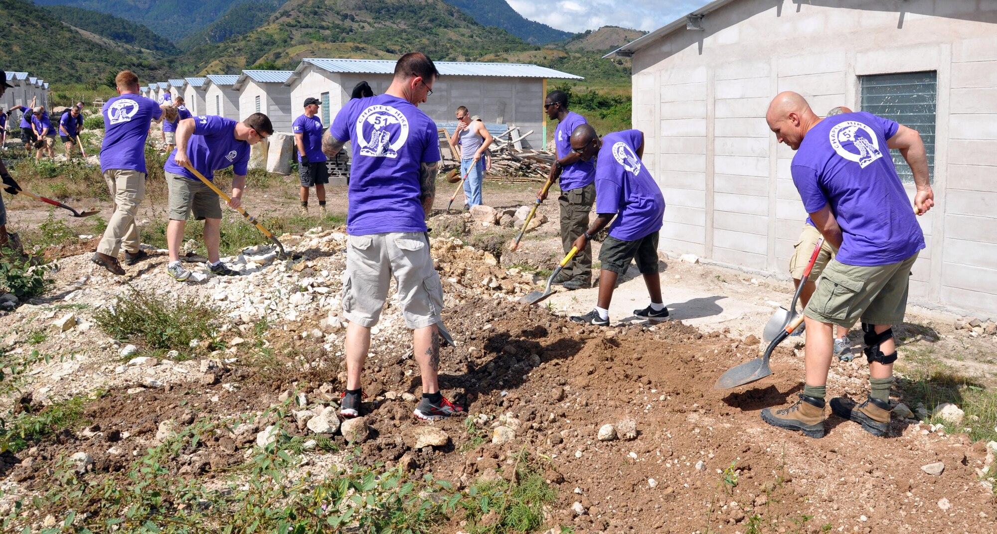 Members of Joint Task Force-Bravo work on clearing and leveling ground for housing in the village of Ajuterique in the Department of Comayagua, Honduras, during the 51st Joint Task Force-Bravo chapel hike, Dec. 14, 2013.  The Task Force members hiked three miles to the village to deliver more than 100 packs of food to families in the community, and then spent the remainder of their time working on a housing project in Ajuterique, doing manual labor to help build homes for families.  (U.S. Air Force photo by Capt. Zach Anderson)