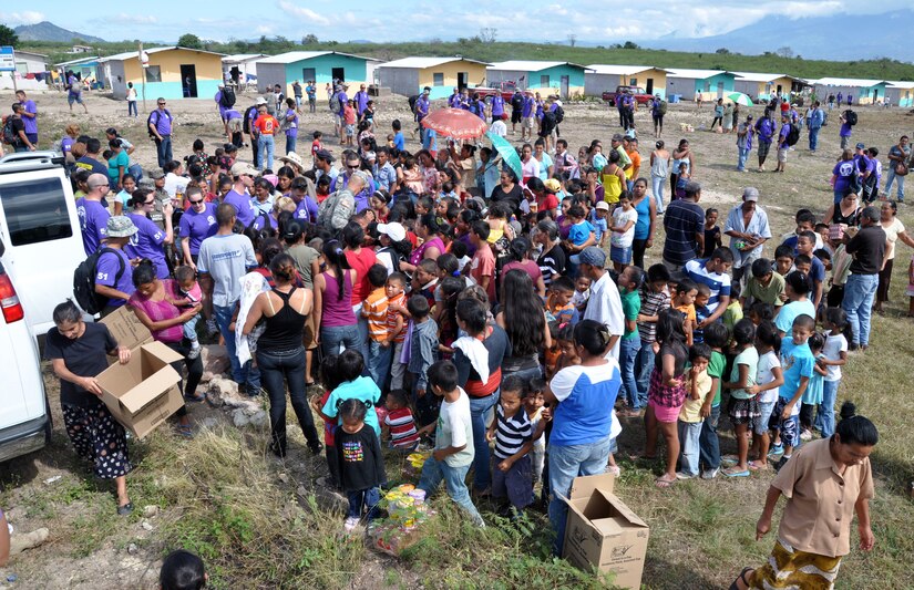 Members of Joint Task Force-Bravo distribute food to families in need in the village of Ajuterique in the Department of Comayagua, Honduras, during the 51st Joint Task Force-Bravo chapel hike, Dec. 14, 2013.  The Task Force members hiked three miles to the village to deliver more than 100 packs of food to families in the community, and then spent the remainder of their time working on a housing project in Ajuterique, doing manual labor to help build homes for families.  (U.S. Air Force photo by Capt. Zach Anderson)