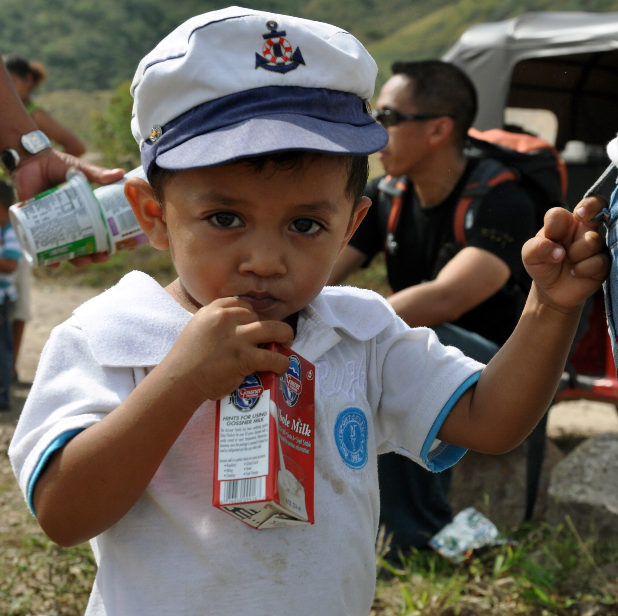 A young Honduran boy enjoys milk that was delivered by members of Joint Task Force-Bravo during the 51st JTF-Bravo Chapel Hike, Dec. 14, 2013.  Members of Joint Task Force-Bravo hiked three-miles to the village of Ajuterique in the Department of Comayagua, Honduras, to deliver more than 100 packs of food to families in need..  The Task Force members then spent the remainder of their time working on a housing project in Ajuterique, doing manual labor to help build homes for families.  (U.S. Air Force photo by Capt. Zach Anderson)