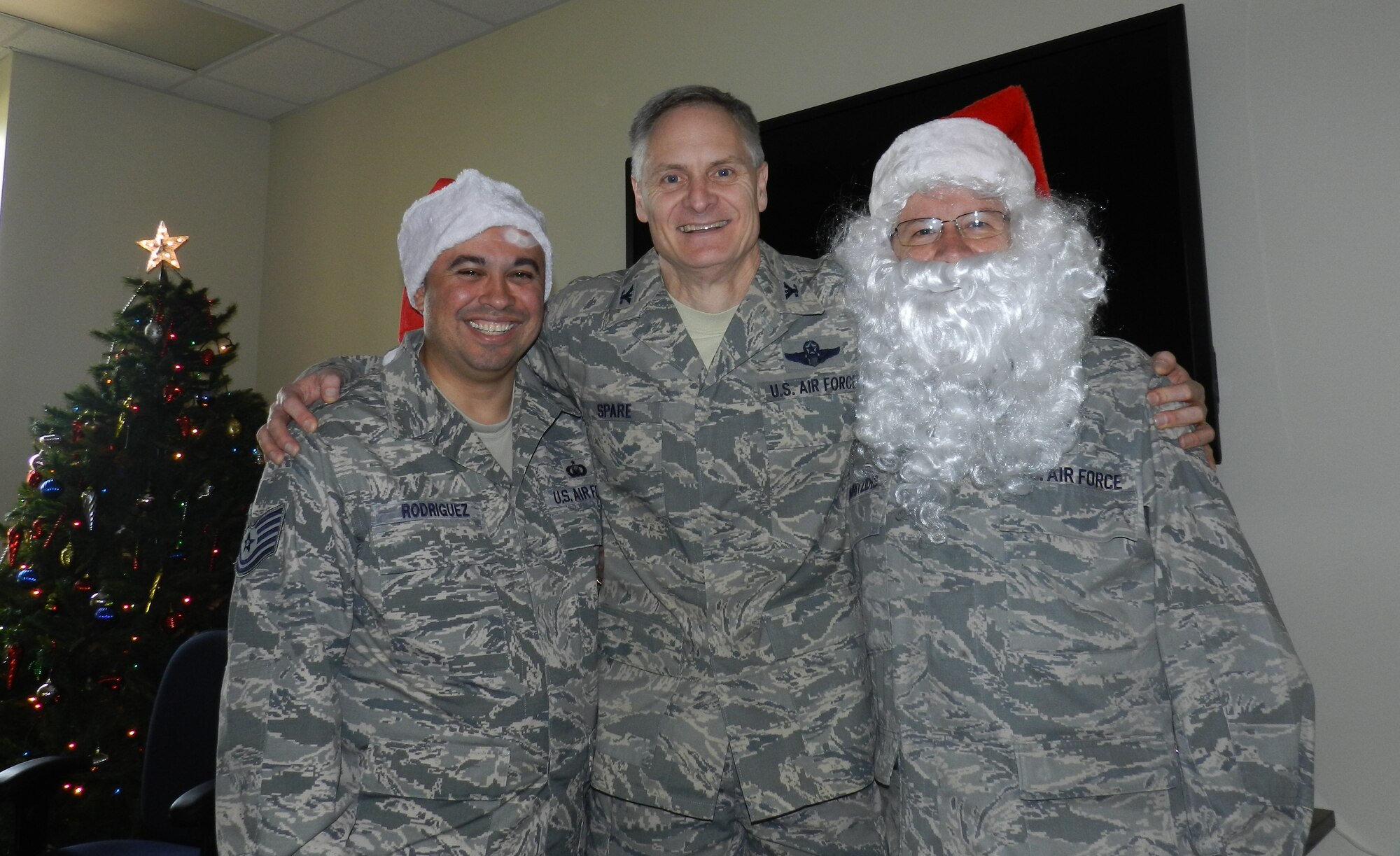 Tech Sgt. Raul Rodriguez, Col. Jonathan Spare and Lt. Col. Peter Souritzidis, 514th Air Mobility Wing staff (left to right), gather in front of the Christmas tree during the holiday lunch held Dec. 7 (U.S. Air Force photo/Tech Sgt. Jingwei Mai).