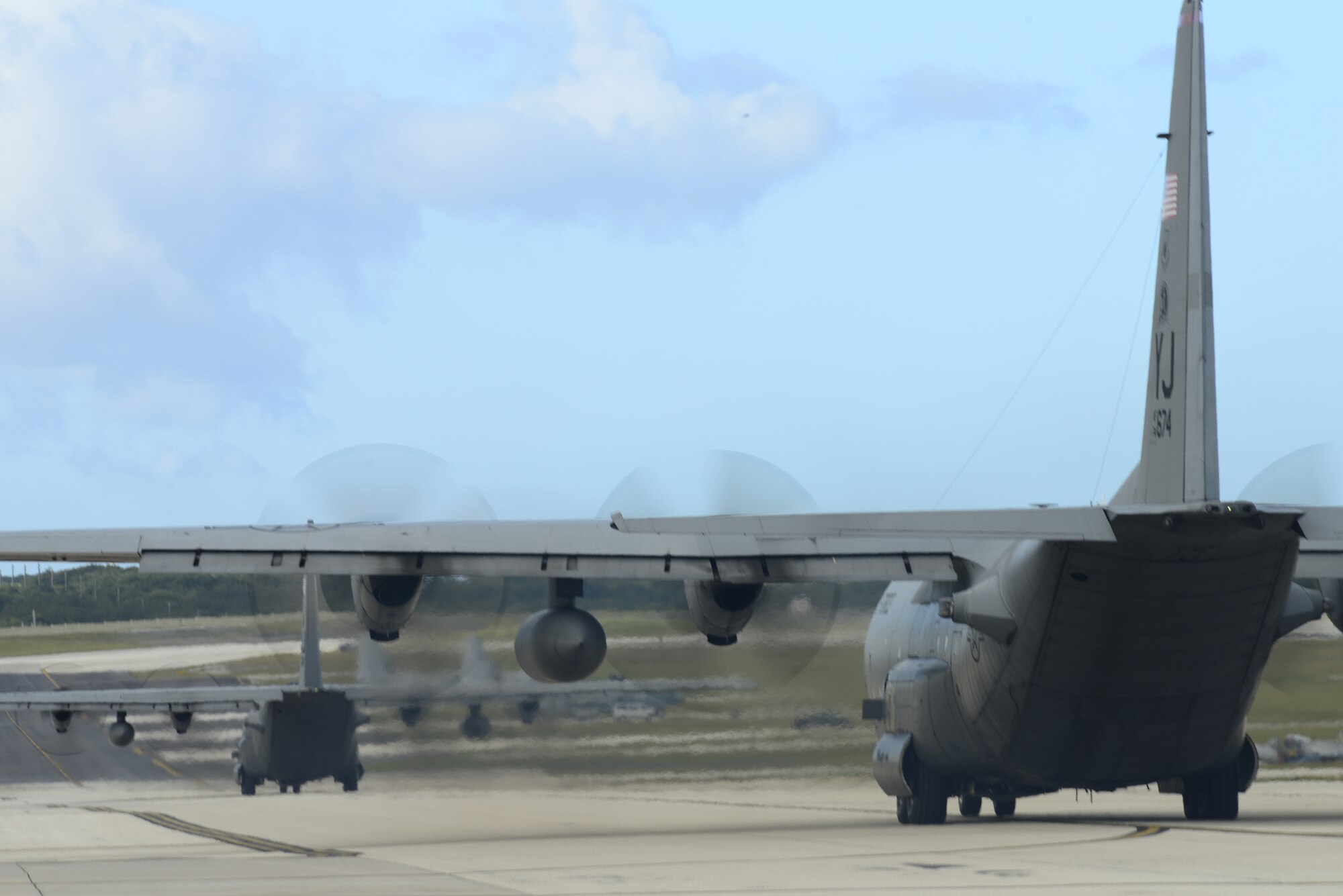 Two C-130 Hercules aircraft from the 374th Airlift Wing, Yokota Air Base, Japan, prepare to take off for an airdrop mission during Operation Christmas Drop at Andersen Air Force Base, Guam, Dec. 11, 2013. This year marks the 62nd year of Operation Christmas Drop, which began in 1952, making it the world's longest running airdrop mission. Every December, C-130 Hercules crews from the 374th Airlift Wing at Yokota Air Base, Japan, partner with the 36th Wing at Andersen Air Force Base, Guam, to airlift food, supplies and toys to islanders throughout Micronesia. (U.S. Air Force photo by 2nd Lt. Jake Bailey/Released)