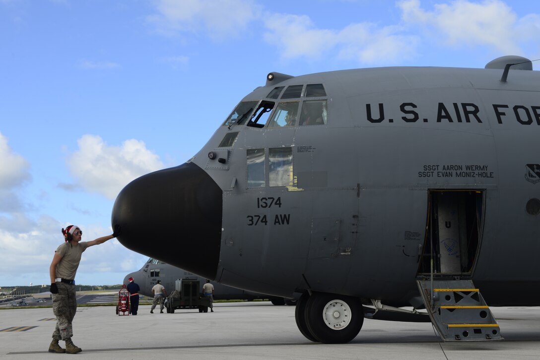 Airman 1st Class Stephen Strapp, a C-130H crew chief assigned to the 374th Aircraft Maintenance Squadron, Yokota Air Base, Japan, prepares an aircraft for an airdrop mission during Operation Christmas Drop at Andersen Air Force Base, Guam, Dec. 11, 2013. This year marks the 62nd year of Operation Christmas Drop, which began in 1952, making it the world's longest running airdrop mission. Every December, C-130 Hercules crews from the 374th Airlift Wing at Yokota Air Base, Japan, partner with the 36th Wing at Andersen Air Force Base, Guam, to airlift food, supplies and toys to islanders throughout Micronesia. (U.S. Air Force photo by 2nd Lt. Jake Bailey/Released)