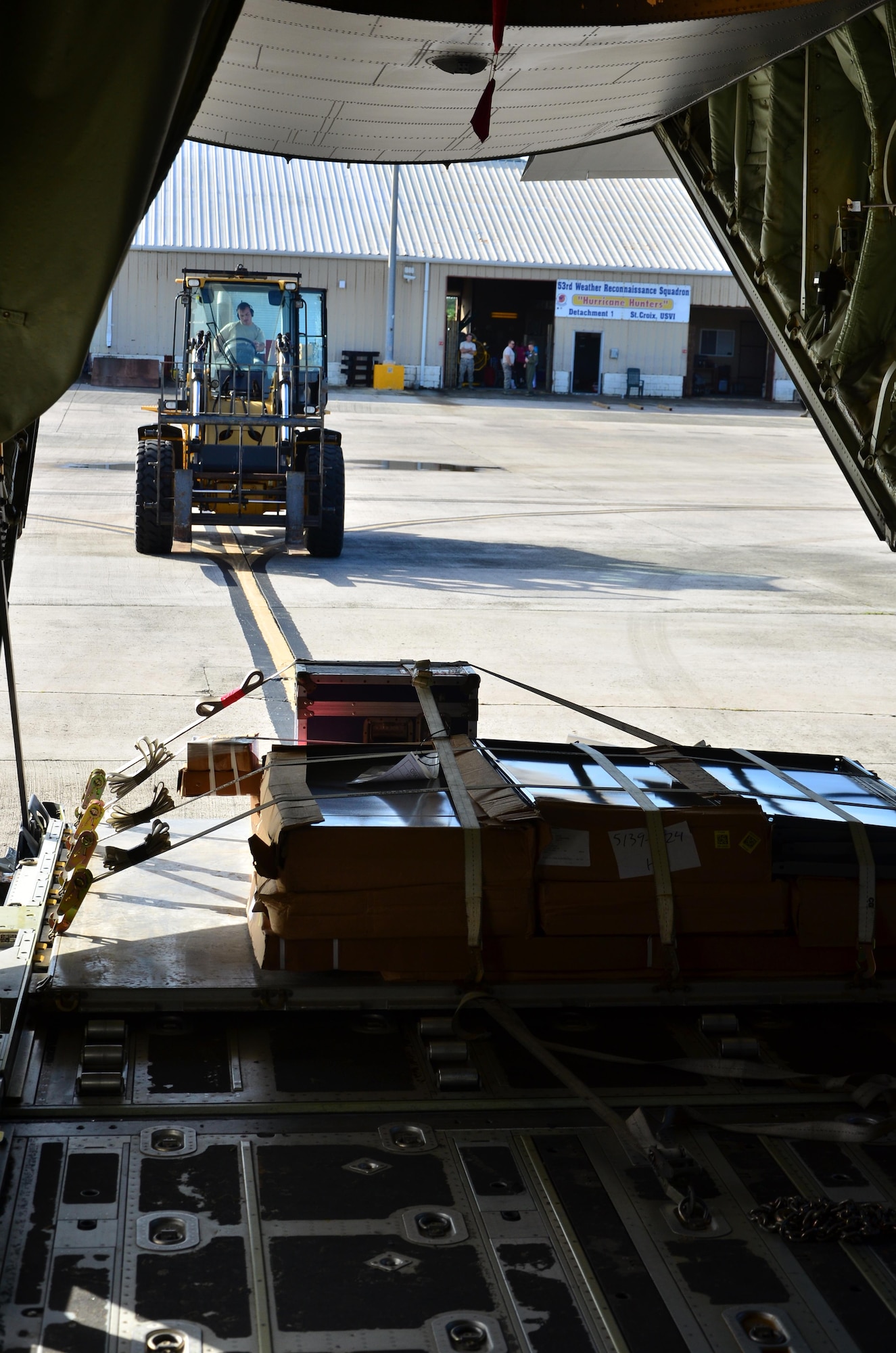 Senior Airman Martin Guthrie, a reservist with the 403rd Wing, Keesler Air Force Base, Miss., uses a forklift to unload a pallet from a WC-130J at the Henry E. Rohlsen Airport, St. Croix, U.S. Virgin Islands, Dec. 12, 2013 during Roll Up. This mission officially closes the 2013 Atlantic Hurricane Hunting operations for the 53rd Weather Reconnaissance Squadron. 