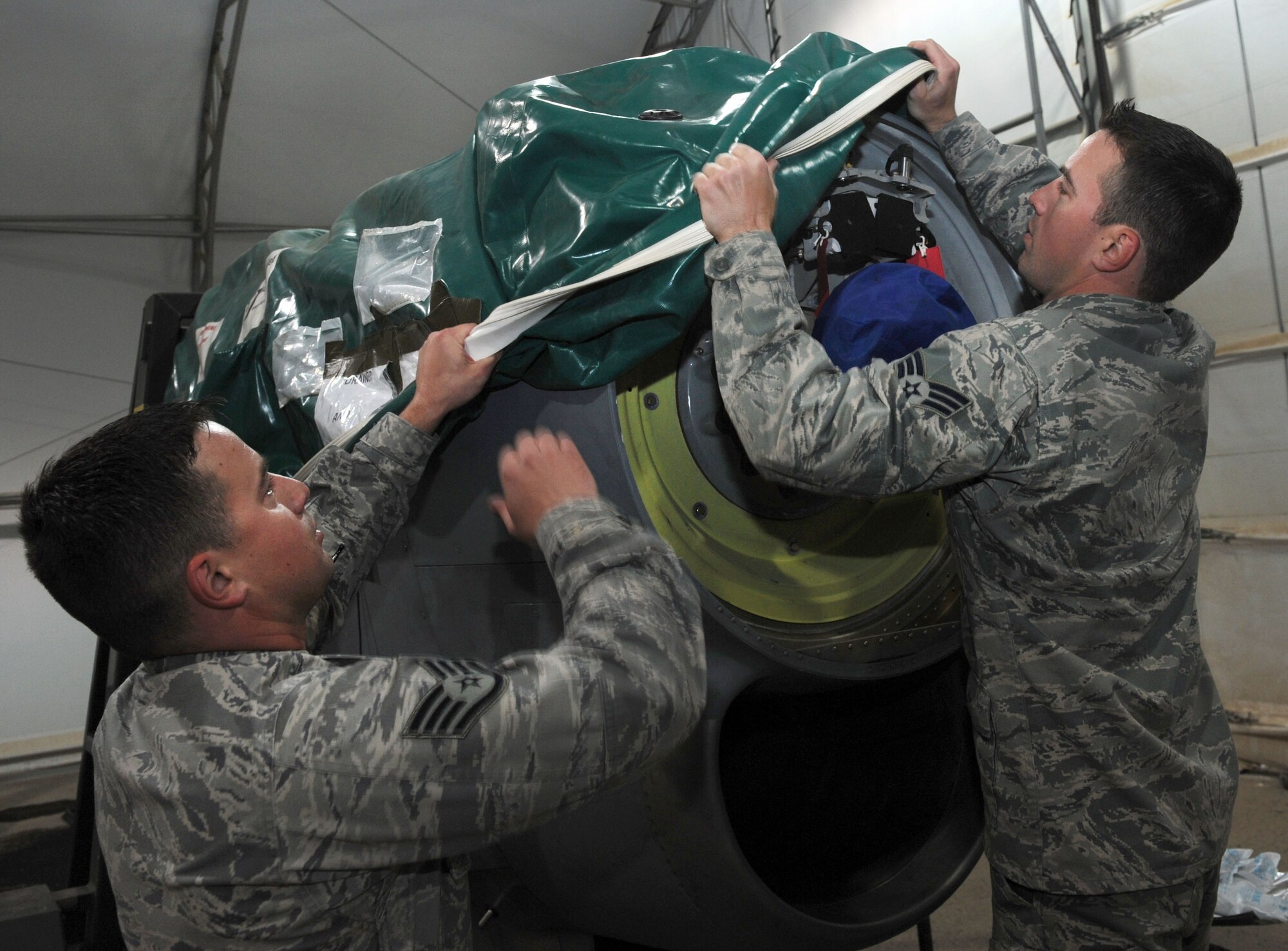 Staff Sgt. William Medeiros and Senior Airman Barrington prepare a spare engine for a C-130 J at an undisclosed location Southeast Asia. The brothers were separated at birth and now serve together with the 386th Expeditionary Aircraft Maintenance Squadron. (U.S. Air Force photo/Senior Airman Desiree W. Moye)