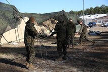 Service members with Ragnarok Company, 2nd Supply Battalion, 2nd Marine Logistics Group disassemble a radio antenna during a field exercise aboard Camp Lejeune, N.C., Dec. 11, 2013. Marines and sailors with the unit used the FEX as an opportunity to practice quickly setting up and taking down equipment and tents before Cold Response 2014, a NATO exercise in Norway. 