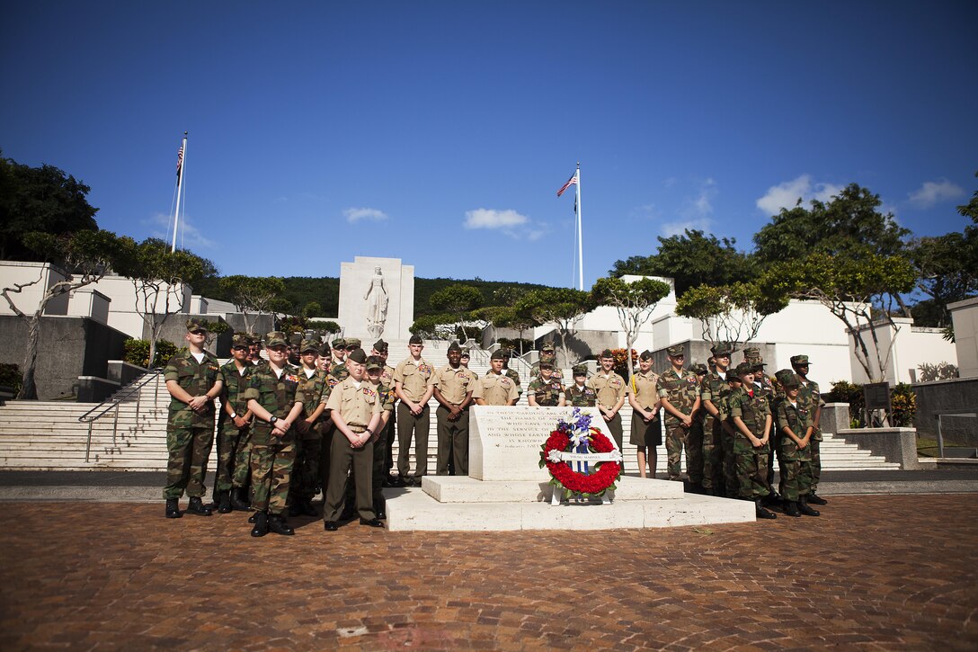 Young Marines from around the nation stand by the headstone at the National Memorial Cemetery of the Pacific after conducting a wreath laying ceremony to pay tribute to fallen service members, Dec. 6, 2013. A total of 67 Young Marines from seven states gathered in Hawaii to commemorate the 72nd anniversary of the attacks on Pearl Harbor. Along with the wreath laying ceremony, the Young Marines participated in a beach clean-up at Marine Corps Base Hawaii and marched in the annual Pearl Harbor Parade in Honolulu, carrying banners representing the 12 ships destroyed during the attack. (U.S. Marine Corps photo by Lance Cpl. Matthew Bragg)