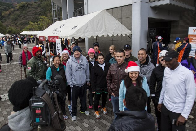 Japanese media talks to station residents from Marine Corps Air Station Iwakuni, Japan, before the Hagi Castle Race that took place in Hagi, Dec. 8, 2013. Approximately 20 athletes from the station competed in the race.