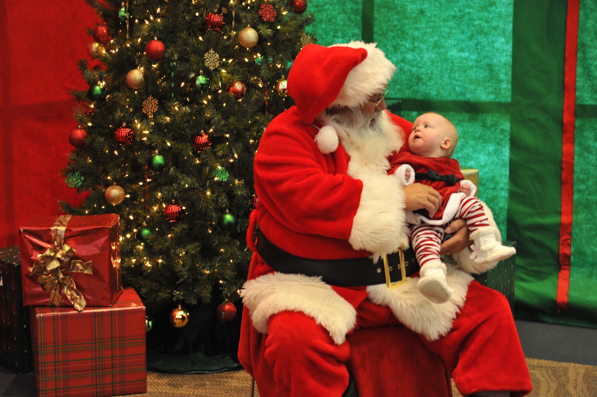 124-Santa Claus holds a child at the Breakfast with Santa event Dec. 14, 2013, at the Leadership Development Center on Buckley Air Force Base, Colo. Breakfast with Santa is an annual event coordinated by the 460th Force Support Squadron that provides families with a pancake breakfast, a visit with Santa, and a gift to every child. (U.S. Air Force Photo by Airman 1st Class Samantha Saulsbury/Released)