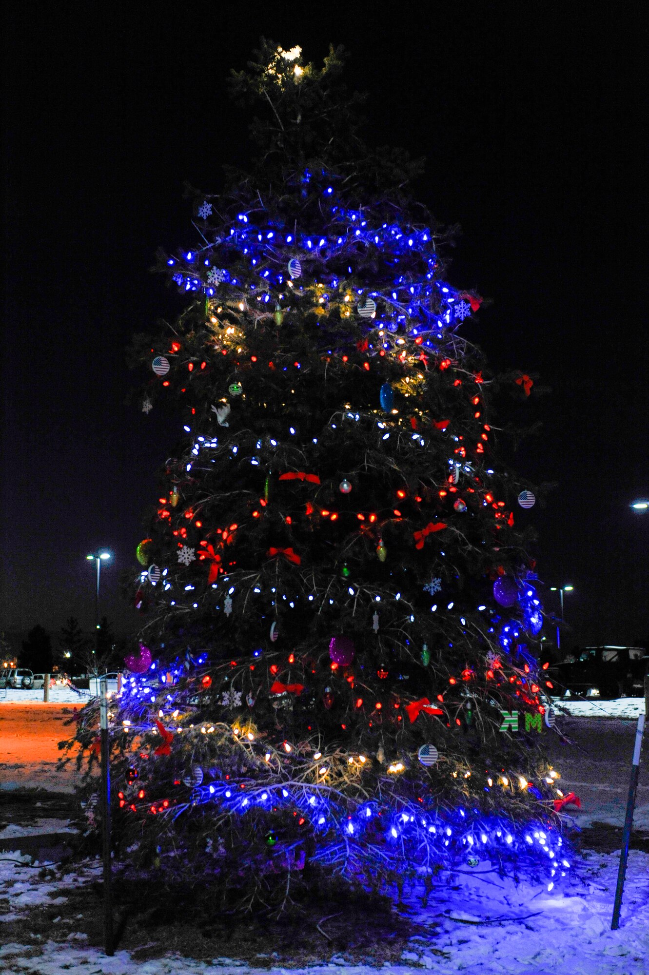 A tree is lit Dec. 9, 2013, on Buckley Air Force Base, Colo., during a tree-lighting ceremony in memory of Kristopher Mansfield, a former 460th Space Communications Squadron Airman who was killed by a drunk driver. Family and friends decorate the tree in celebration of Mansfield’s life and what he meant to the squadron. (U.S. Air Force photo by Airman 1st Class Samantha Saulsbury/Released)