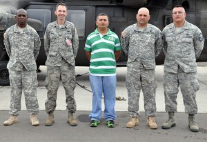 U.S. Army Staff Sgt. Willie Price, U.S. Air Force Capt. Allen Bear, Jose Adalberto Mejia, U.S. Army Staff Sgt. John Fowler, and U.S. Air Force Master Sgt. Michael Batres were recognized for their actions in assisting at the scene of a vehicle accident, Soto Cano Air Base, Honduras, Dec. 16, 2013.  On the evening of Dec. 11, 2013, Adalberto Mejia was driving a taxi with the four service members riding as passengers when the men witnessed a vehicle striking a cow that had wandered onto the road. The vehicle flipped upside down and came to rest in a ditch. The five men came to the aid of the driver of the overturned vehicle, pulling him from the wreckage and then loading him into the taxi to transport him to receive medical treatment. (U.S. Air Force photo by Capt. Zach Anderson)