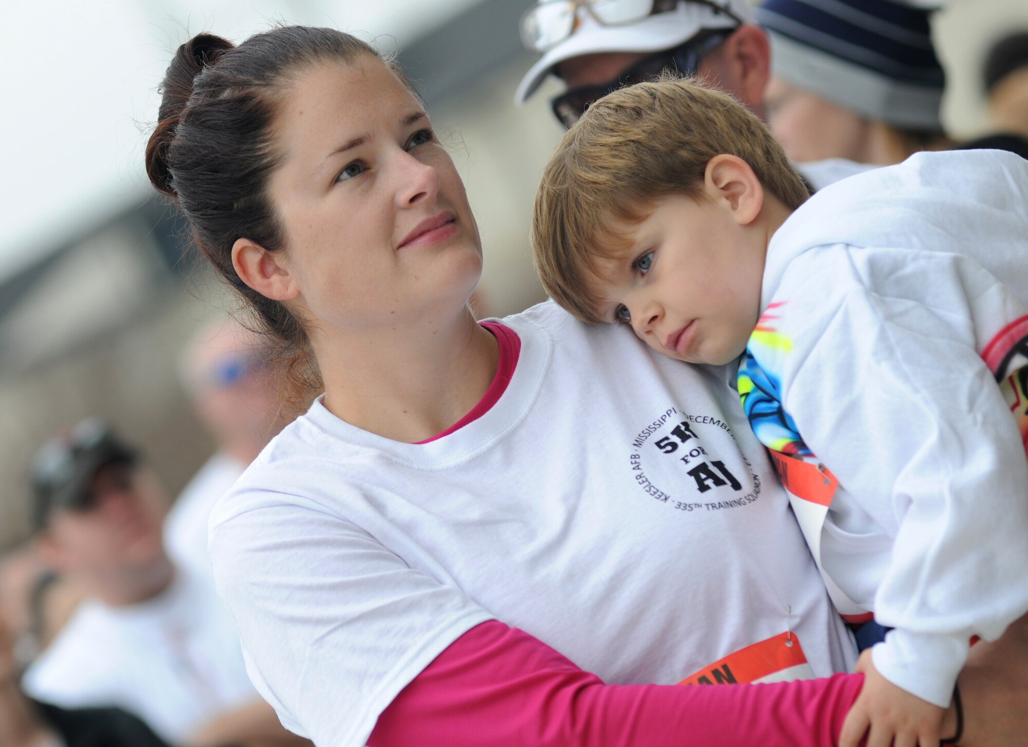 Staff Sgt. Ashley Jackson, 335th Training Squadron, holds her son close during the “5K for AJ” benefit run Dec. 14, 2013, Keesler Air Force Base, Miss. The 5K run was held to raise money for Master Sgt. Albert “AJ” Jackson, 335th TRS, who was paralyzed from a medical procedure. The event, organized by the 335th TRS “Bulls,” raised more than $15,700 to assist the family.  (U.S. Air Force photo by Kemberly Groue)