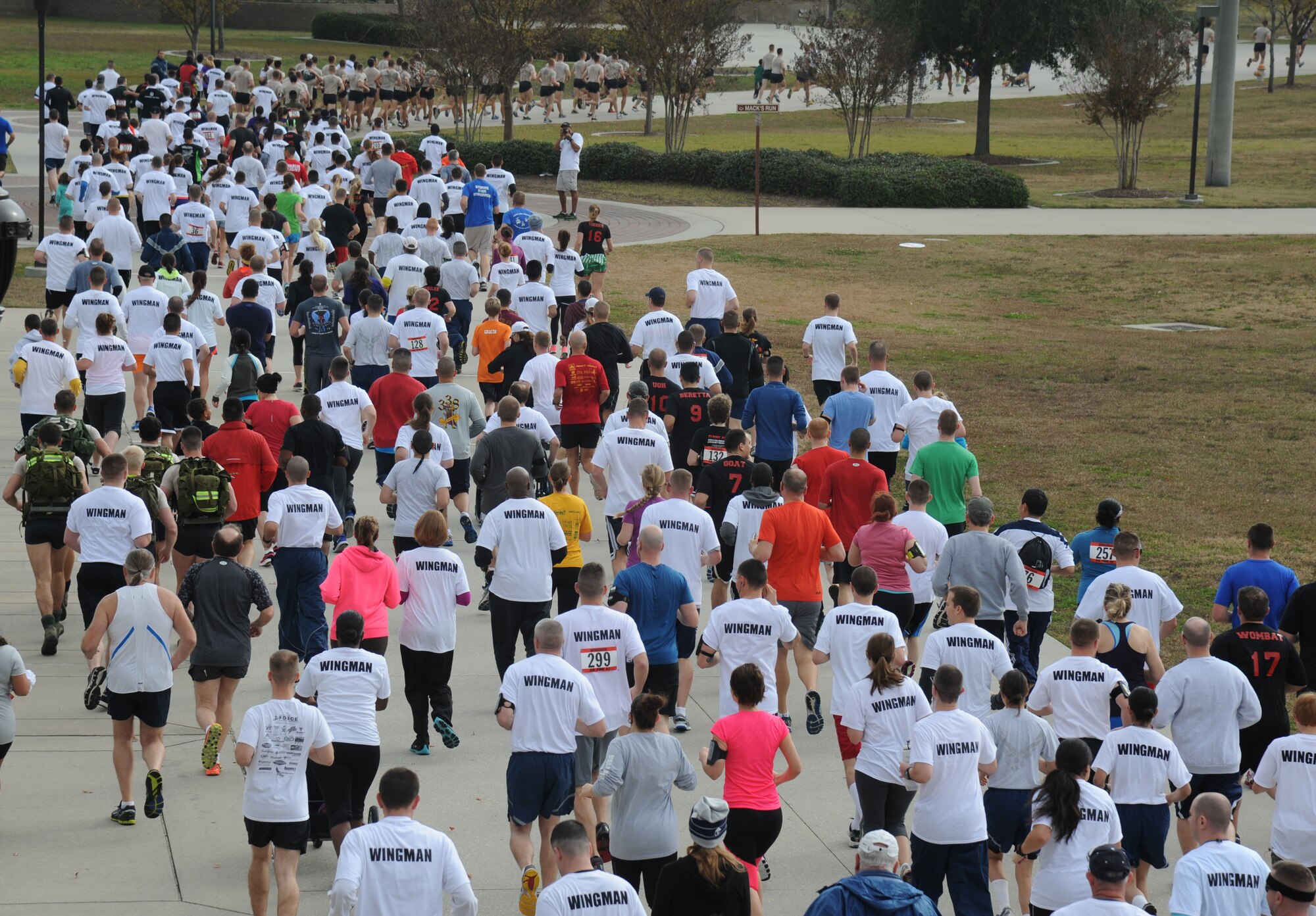 Airmen display their “wingman” shirts as they participate in the “5K for AJ” benefit run Dec. 14, 2013, Keesler Air Force Base, Miss. The 5K run was held to raise money for Master Sgt. Albert “AJ” Jackson, 335th TRS, who was paralyzed from a medical procedure. The event, organized by the 335th TRS “Bulls,” raised more than $15,700 to assist the family.  (U.S. Air Force photo by Kemberly Groue)