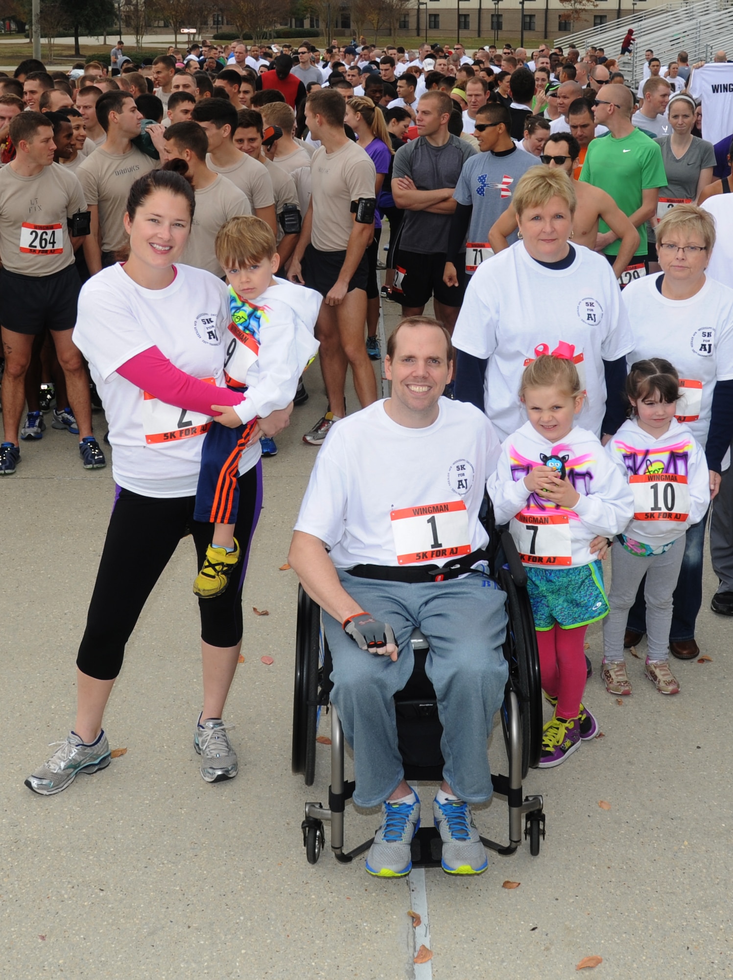 Staff Sgt. Ashley Jackson and her husband, Master Sgt. Albert “AJ” Jackson, 335th Training Squadron, take a photo with their children and family members at the “5K for AJ” benefit run Dec. 14, 2013, Keesler Air Force Base, Miss. The event, organized by the 335th TRS “Bulls,” was held to raise money for AJ, who was paralyzed from a medical procedure.  (U.S. Air Force photo by Kemberly Groue)
