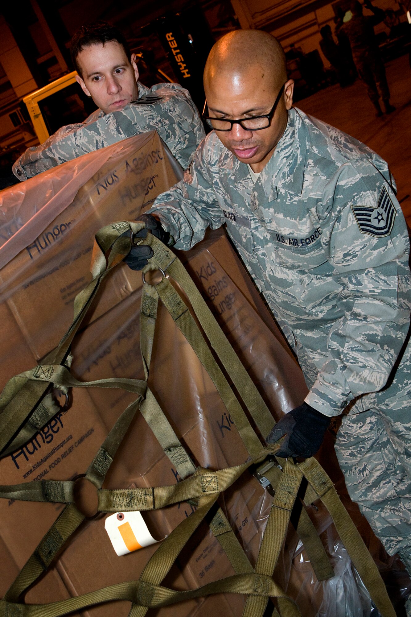 Tech. Sgt. Kevin Black, front, and Tech. Sgt. Michael Darnell, both 434th Logistics Readiness Squadron supply management craftsmen, prepare food for shipment aboard a KC-10 Extender aircraft at Grissom Air Reserve Base, Ind., Dec. 7,2013. Grissom's Air Force reservists partnered with Airmen from Joint Base McGuire-Dix-Lakehurst N.J., and Charleston AFB, S.C., to provide more than 45,000 pounds of food to Haiti as part of a humanitarian relief mission under the Denton Program.  (U.S. Air Force photo/Senior Airman Jami K. Lancette)
