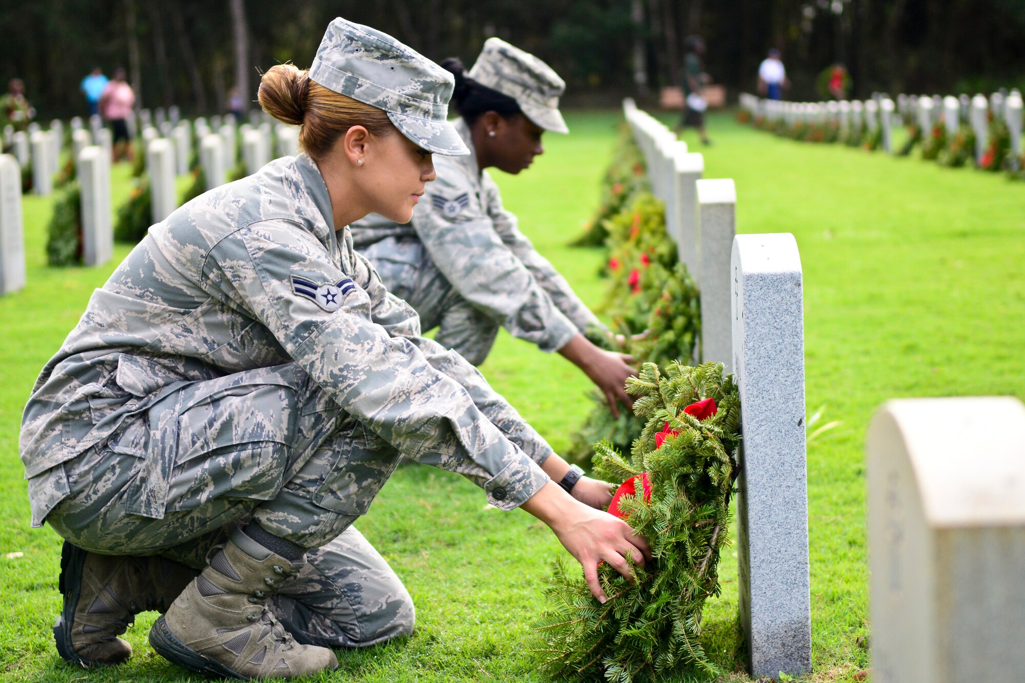 Airman 1st Class Janyzel Colon and Senior Airman Cherrelle Warren, 6th Medical Operations Squadron aerospace medical technicians, lay wreaths on graves at the Florida National Cemetery in Bushnell, Fla., Dec. 14, 2013. More than 5,000 participants laid 9,200 wreaths. (U.S. Air Force photo by Airman 1st Class Ned T. Johnston/Released)