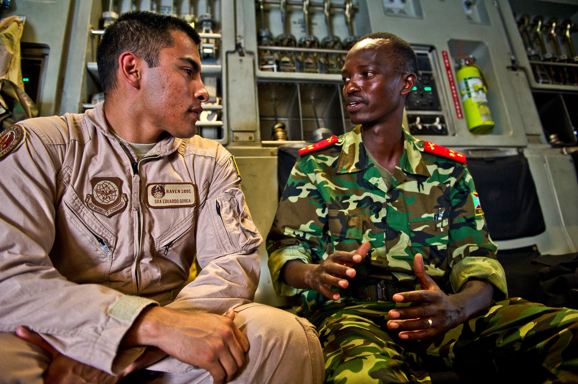 Senior Airman Edurado Govea, a Security Forces Phoenix Raven, speaks with a Burundi soldier before take off in a C-17 Globemaster Dec. 13, 2013 at Bujmumbura Airport, Burundi. In coordination with the French military and African Union, the U.S. military provided airlift support to transport Burundi soldiers, food and supplies in the Central African Republic. This support is aimed at enabling African forces to deploy promptly to prevent further spread of sectarian violence and restore security in CAR. (U.S. Air Force photo/Staff Sgt. Erik Cardenas)