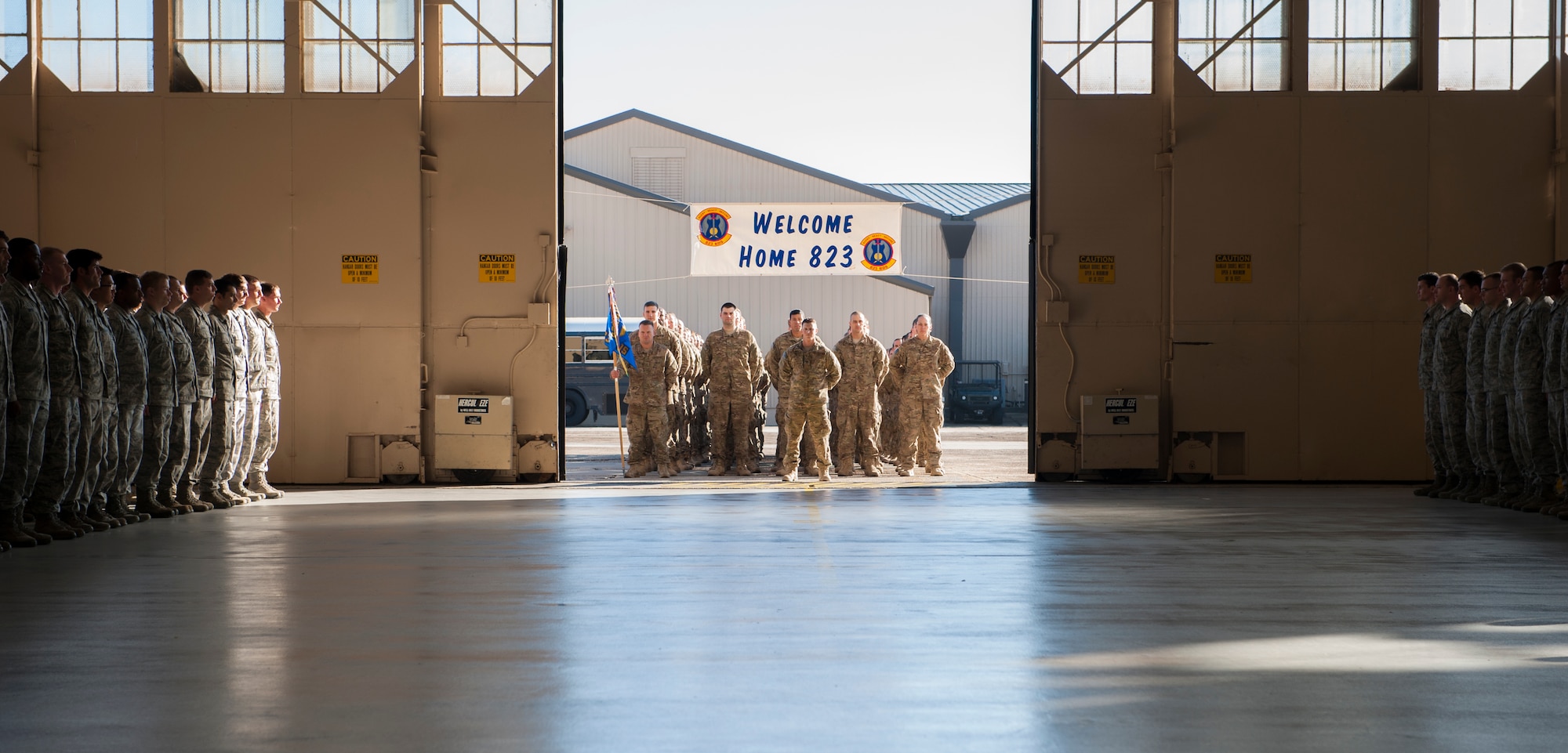 Doors open to reveal Airmen from the 823d Base Defense Squadron at Moody Air Force Base, Ga., Dec. 16, 2013. Family, friends and fellow Airmen formed a pathway as the returning deployed members marched their way into the hangar. (U.S. Air Force Airman 1st Class Alexis Grotz/ Released)