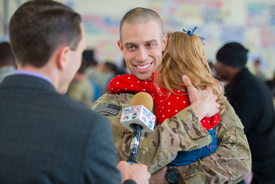 U.S. Air Force Staff Sgt. Dallas Ayers, 823d Base Defense Squadron fire team member, answers questions during an interview following his deployment return at Moody Air Force Base, Ga., Dec. 16, 2013. Ayers reunited with his daughter after a six-month deployment to Bagram Airfield, Afghanistan. (U.S. Air Force photo by Airman 1st Class Ryan Callaghan/Released)
