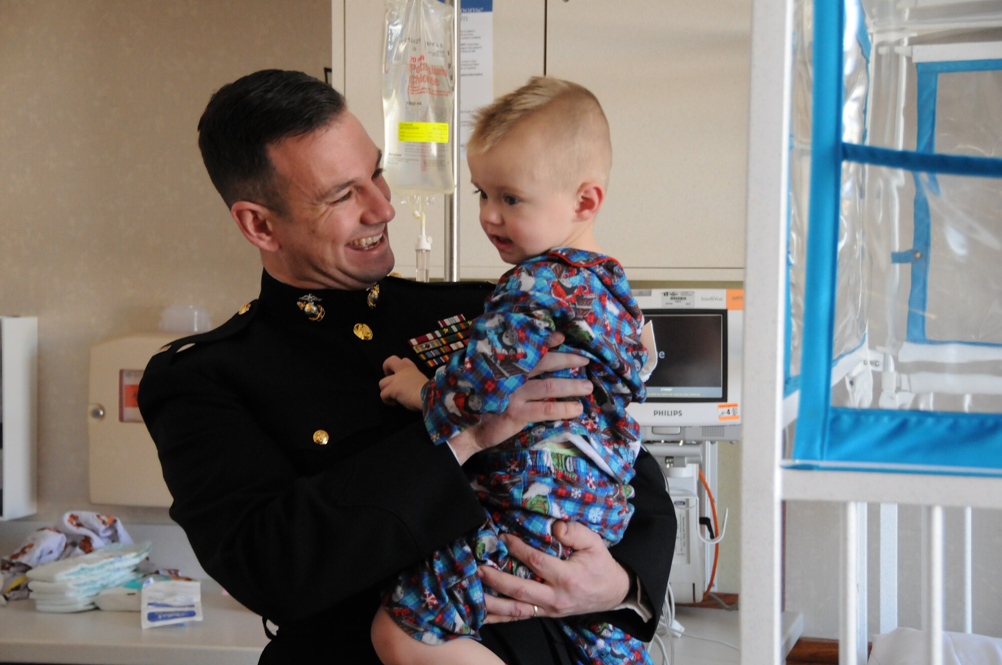 YOUNGSTOWN AIR RESERVE STATION, Ohio—Chief Warrant Officer 4 Michael Hudson, Inspector/Instructor of the Marine Corps Reserve Detachment-3 Maintenance Company (Det-3) based at YARS, holds 2-year-old Jacob while visiting the Boardman campus of Akron Children’s Hospital, Dec. 16. Several YARS members visited the hospital to spread holiday cheer, passing out toys collected during Det.-3’s Toys for Tots campaign, along with Air Force promotional items and wing patches. This year’s hospital visit marked the fourth consecutive December trip. (U.S. Air Force photo/Eric M. White)
