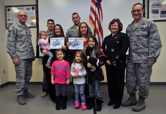 Col. Newberry, 92nd Air Refueling Wing commander, his wife, Jill, and Chief Master Sgt. Lance Turner, 92nd Medical Group superintendent, presents the Blue Star Spouse Award to Ms. Amber Meza and Ms. Jeannine Collins, at Fairchild Air Force Base, Wash., Dec. 13, 2013. Their husband's, Master Sgt. Eric Meza and Tech. Sgt. Ken Collins, both from the 92nd Civil Engineer Squadron, and their children, were present to help congratulate them.  These two dedicated 92nd CES spouses were presented the award for their innovation in setting up a key spouse office in the squadron and passionately connecting new Airmen and their families to the squadron.   Anyone interested in nominating someone for the Blue Star Spouse Award should contact their squadron commander. (U.S. Air Force photo by Staff Sgt. Veronica Montes)