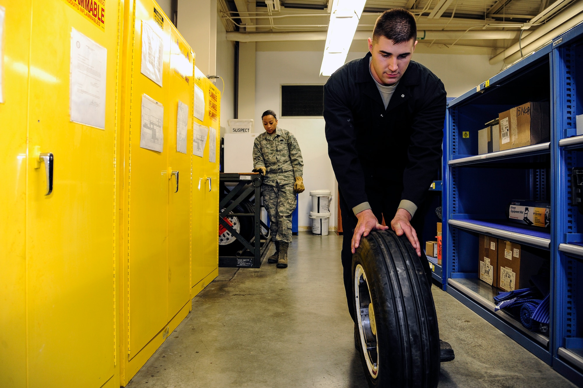 Senior Airman Ryan Oaten, 354th Aircraft Maintenance Squadron crew chief, rolls an aircraft tire away after having it checked out from Senior Airman Heidi Agustin, 354th Aircraft Maintenance Squadron combat oriented supply organization technician, Dec. 11, 2013, Eielson Air Force Base, Alaska. Maintainers receive supplies from COSO which are used to fix or replace parts on Eielson’s aircraft. (U.S. Air Force photo by Senior Airman Zachary Perras/Released)