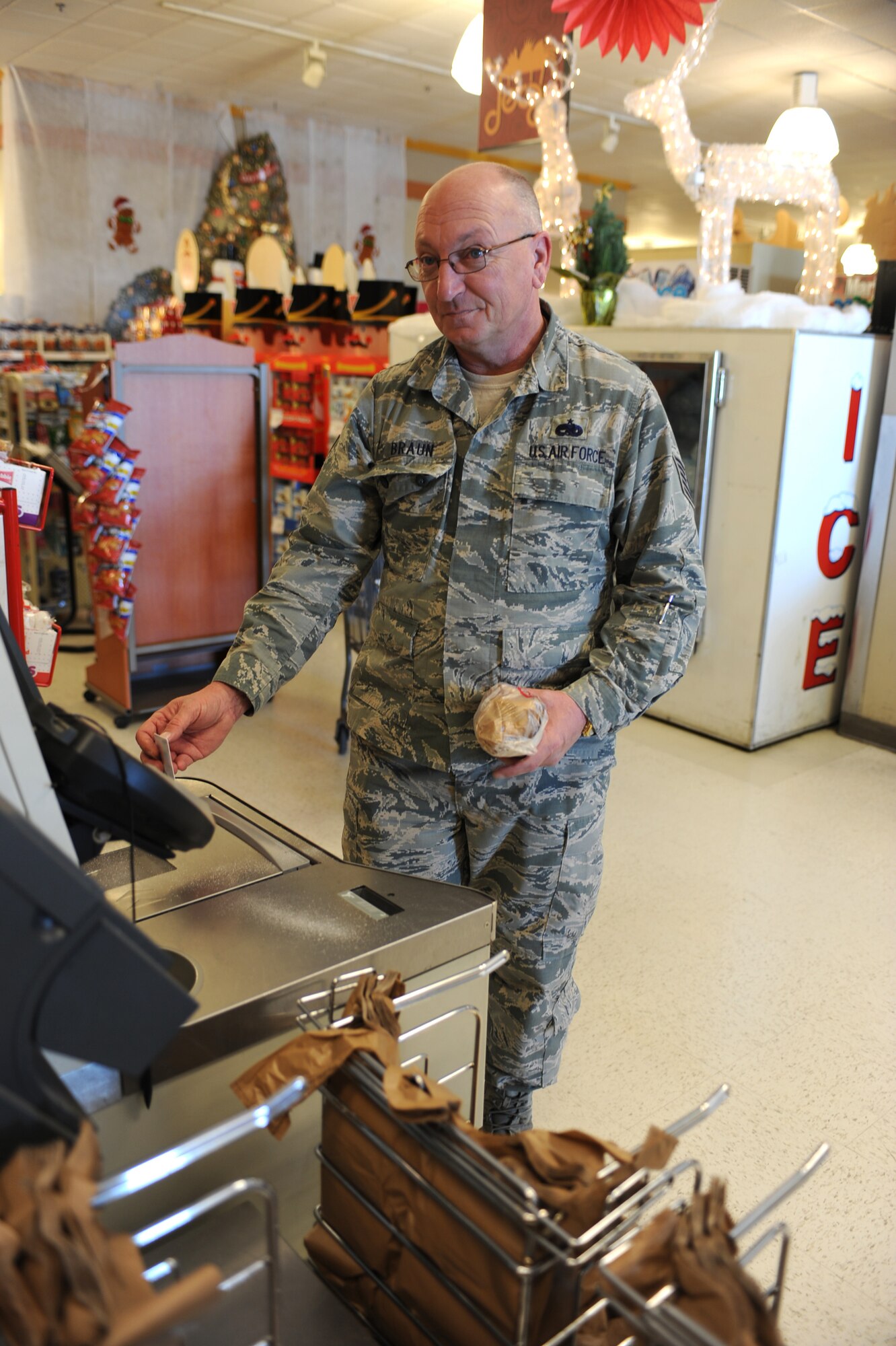 U.S. Air Force Tech. Sgt. Gary Braun, 924th Fighter Squadron, scans his Department of Defense ID card before making his purchase in the commissary at Davis-Monthan Air Force Base, Ariz., Dec. 13, 2013.  In addition to the positive identity verification, scanning identification cards allows Defense Commissary Agency to better understand the patrons and their preferences. (U.S. Air Force Photo by Airman 1st Class Chris Massey/Released)
