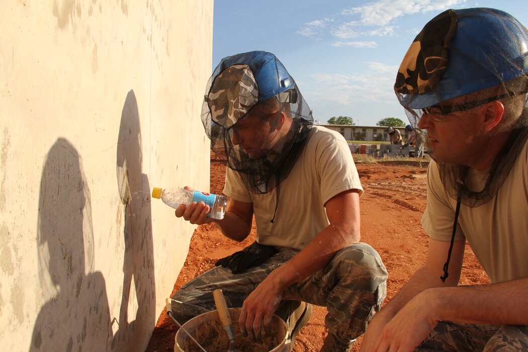 SSgt. Josh David and SSgt. Nathan Jones apply a mortar patch to finish walls on the CBAN radar platform while on a volunteer Deployment for Training in Exmouth, Western Australia. (Utah Air National Guard photo by CMSgt Mark Savage/RELEASED)