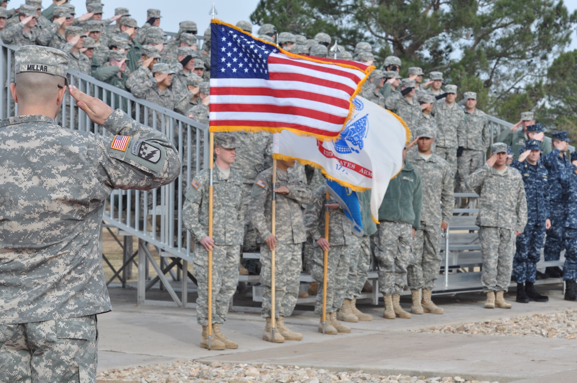 GOODFELLOW AIR FORCE BASE, Texas – Spectators salute the flag during the national anthem at the Army-Navy flag football game at the Mathis Fitness Center football field Dec. 11. The 344th Military Intelligence Battalion and the Navy Center for Information Dominance Detachment face-off every year before the Army-Navy college football game. (U.S. Air Force photo/ Airman 1st Class Erica Rodriguez)