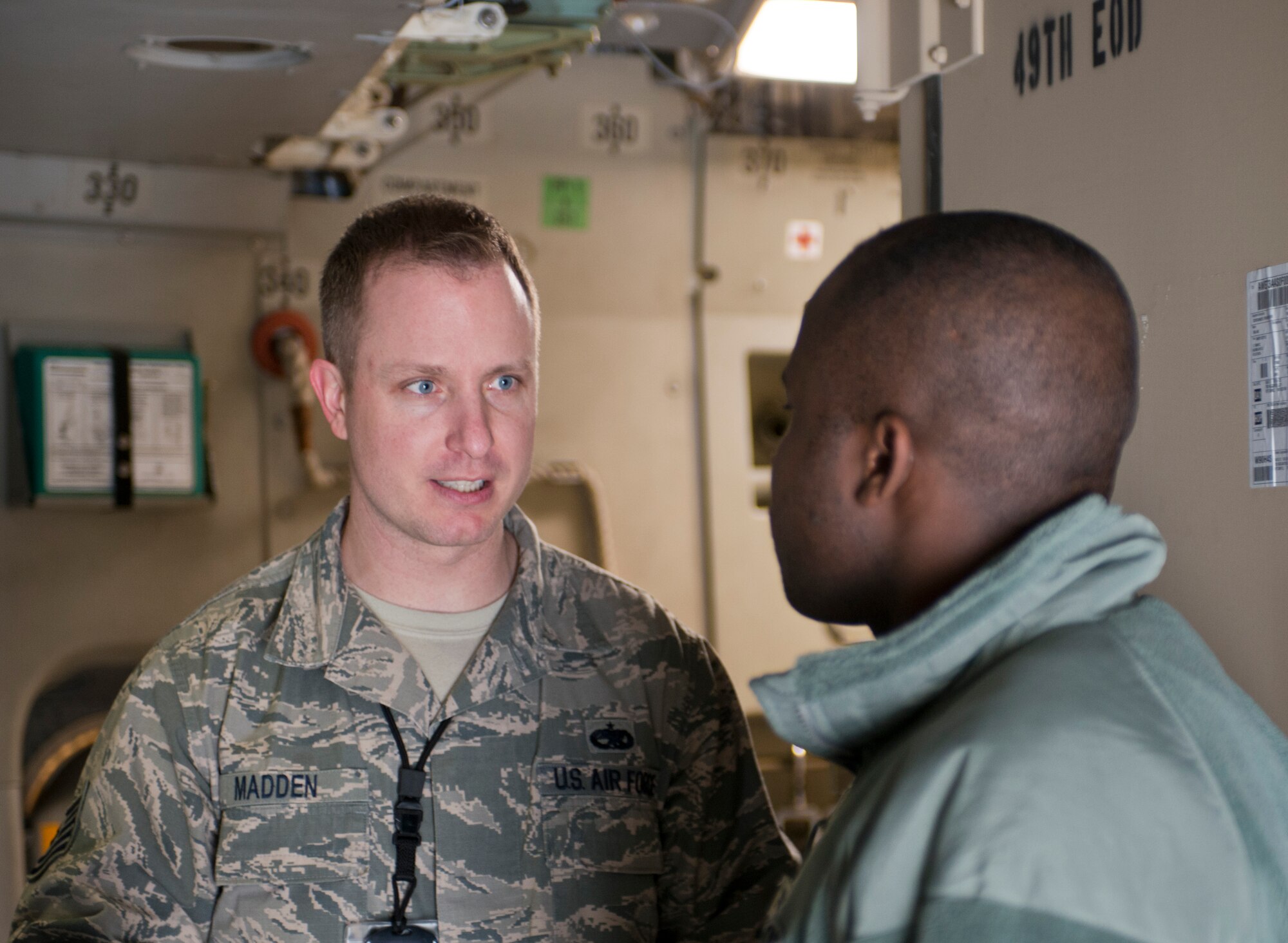 Tech. Sgt. Jeremiah Madden, 721st Aircraft Maintenance Squadron, talks with Staff Sgt. Rudolph Richards, 86th Airlift Wing chaplain assistant, about the mission of the 721st AMXS, Dec. 6, 2013, Ramstein Air Base, Germany. Chaplain assistants dedicate a majority of their day visiting and talking with Airmen around base in hopes to motivate and increase morale as well as be someone to talk to. (U.S. Air Force photo/Senior Airman Jonathan Stefanko)