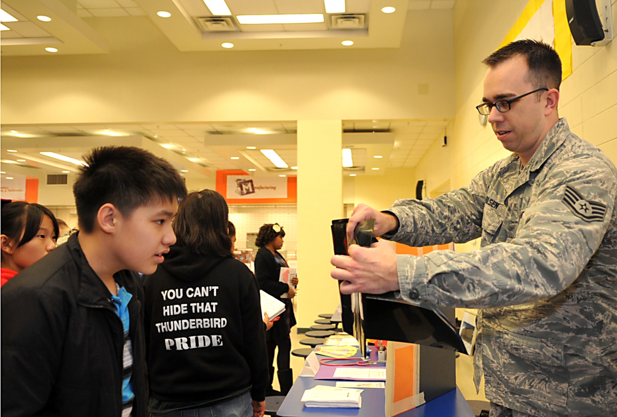 Tech. Sgt. Dustin Carlsen, 51st Medical Operations Squadron ultrasound technician, explains an X-ray to an Osan Middle School student during a career fair at Osan Air Base, Republic of Korea, Dec. 13, 2013. Students were required to ask questions about displays that interested them to learn more about specific careers. (U.S. Air Force photo/Airman 1st Class Ashley J. Thum)