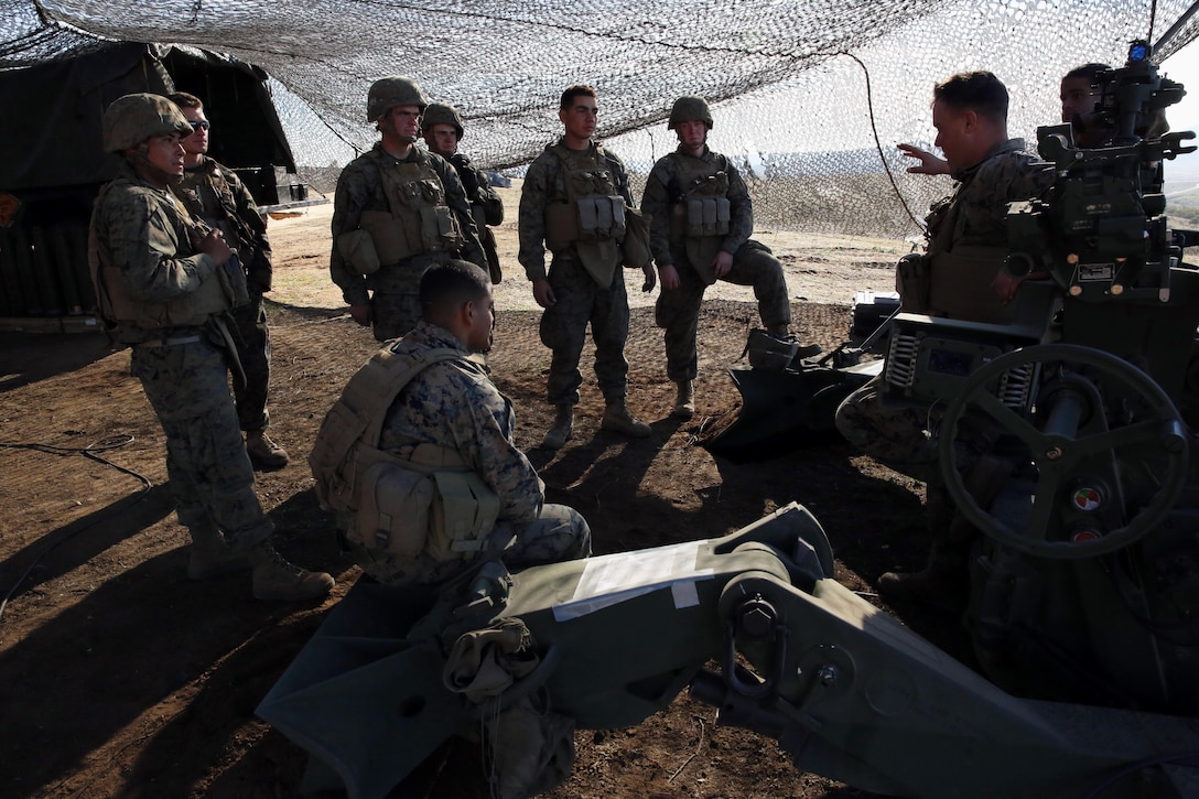 Corporal Ryan C. Howard (right), section chief with Bravo Battery, 1st Battalion, 11th Marine Regiment, and native of Trabuco Canyon, Calif., informs his Marines of their responsibility and expectations before a fire mission during Exercise Steel Knight 2014 at Marine Corps Base Camp Pendleton, Dec. 13, 2013.  Steel Knight is a large-scale, combined arms, live fire exercise integrating the ground combat element from 1st Marine Division with aviation and logistical support from 3rd Marine Aircraft Wing and 1st Marine Logistics Group.  The exercise enables I Marine Expeditionary Force to test and refine its command and control capabilities while honing its conventional warfighting skills. (U.S. Marine Corps photo by Cpl. Michael Wick/Released)