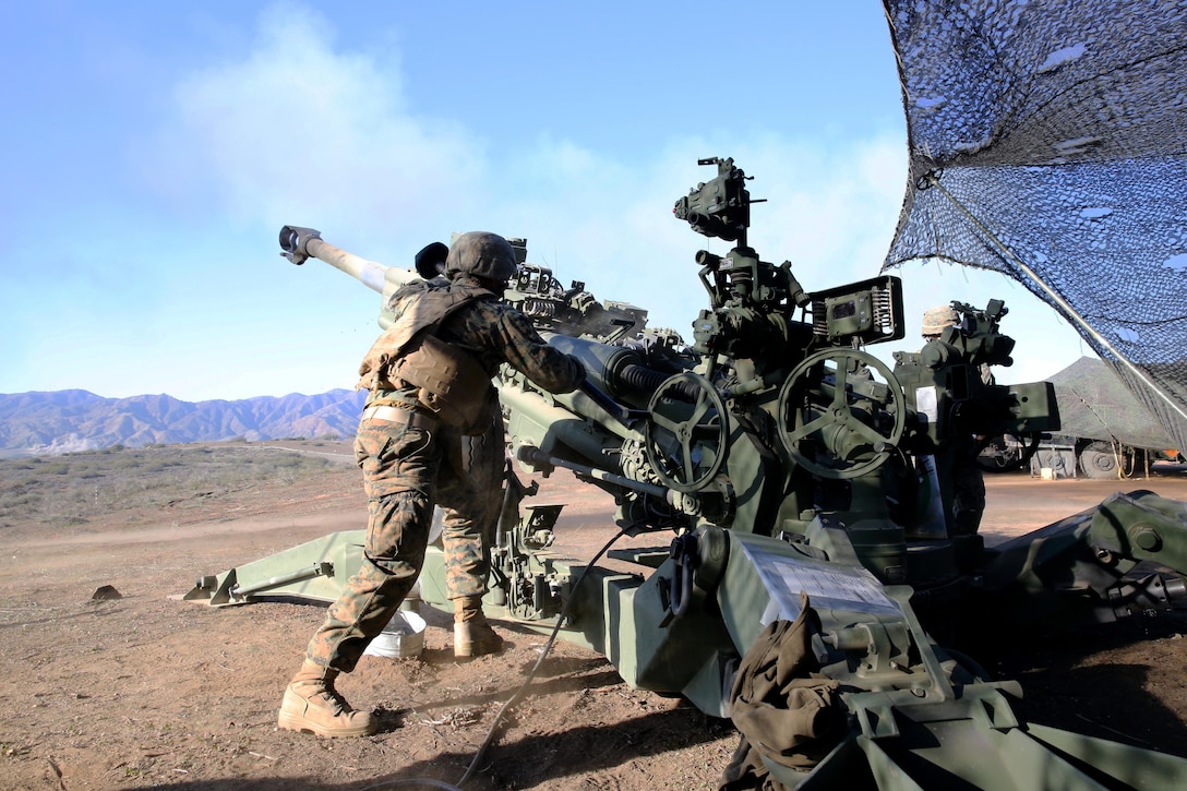 Private First Class Arnold Millan, artilleryman with Bravo Battery, 1st Battalion, 11th Marine Regiment, and a native of Phoenix, Ariz., swiftly rushes to the M777 lightweight howitzer to clear the barrel and reload after firing a mission in support of Exercise Steel Knight 2014 at Marine Corps Base Camp Pendleton, Dec. 13, 2013.  Steel Knight is a large-scale, combined arms, live fire exercise integrating the ground combat element from 1st Marine Division with aviation and logistical support from 3rd Marine Aircraft Wing and 1st Marine Logistics Group.  The exercise enables I Marine Expeditionary Force to test and refine its command and control capabilities while honing its conventional warfighting skills. (U.S. Marine Corps photo by Cpl. Michael Wick/Released)