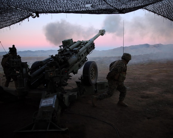 Corporal Daniel I. Alfaro (right), assistant chief with Bravo Battery, 1st Battalion, 11th Marine Regiment, and a native of Houston, Texas, pulls the lanyard after receiving orders to fire in support of Exercise Steel Knight 2014 at Marine Corps Base Camp Pendleton, Dec. 13, 2013.  Steel Knight is a large-scale, combined arms, live fire exercise integrating the ground combat element from 1st Marine Division with aviation and logistical support from 3rd Marine Aircraft Wing and 1st Marine Logistics Group.  The exercise enables I Marine Expeditionary Force to test and refine its command and control capabilities while honing its conventional warfighting skills. (U.S. Marine Corps photo by Cpl. Michael Wick/Released)