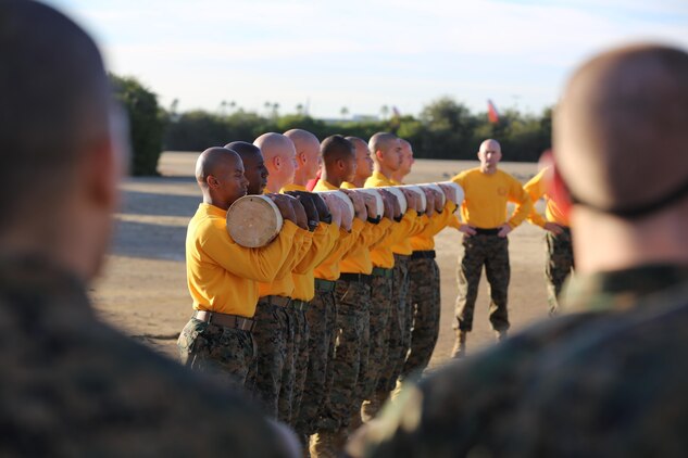 Company F, 2nd Recruit Training Battalion, drill instructors demonstrate how to properly carry and perform exercises with a log to recruits during log drills aboard Marine Corps Recruit Depot San Diego, Nov. 26.  Team-focused events such as log drills help instill the importance of good teamwork and how important it is.