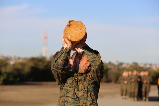 Recruits of Company F, 2nd Recruit Training Battalion, perform log lifts during log drills aboard the depot, Nov. 26.  The sheer weight of the log posed great challenges for the recruits.  They had to figure out how to push through and not fail their group.