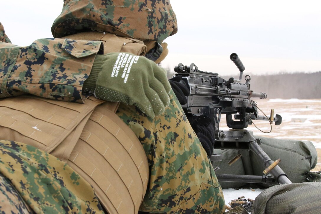 An assistant gunner places his hand to signal a Marine firing a M249 squad Automatic Weapon at Range 14 aboard Marine Corps Base Quantico on Dec. 11, 2013. The Finance Section Marines also fired the M240B machine gun.