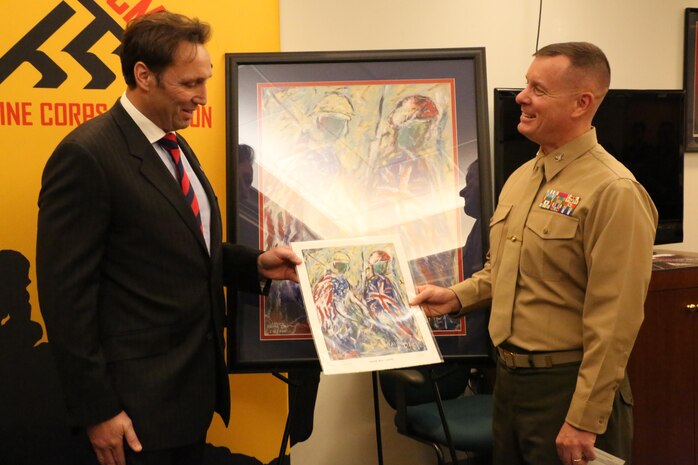 Col. David Maxwell, commanding officer of Marine Corps Base Quantico, receives a gift from Stuart Taylor, director of the Allied Forces Foundation, presents, at the Marine Corps Marathon conference room Dec. 13, 2013. The print was a thank you gift for hosting wounded warriors during the Marine Corps Marathon. 