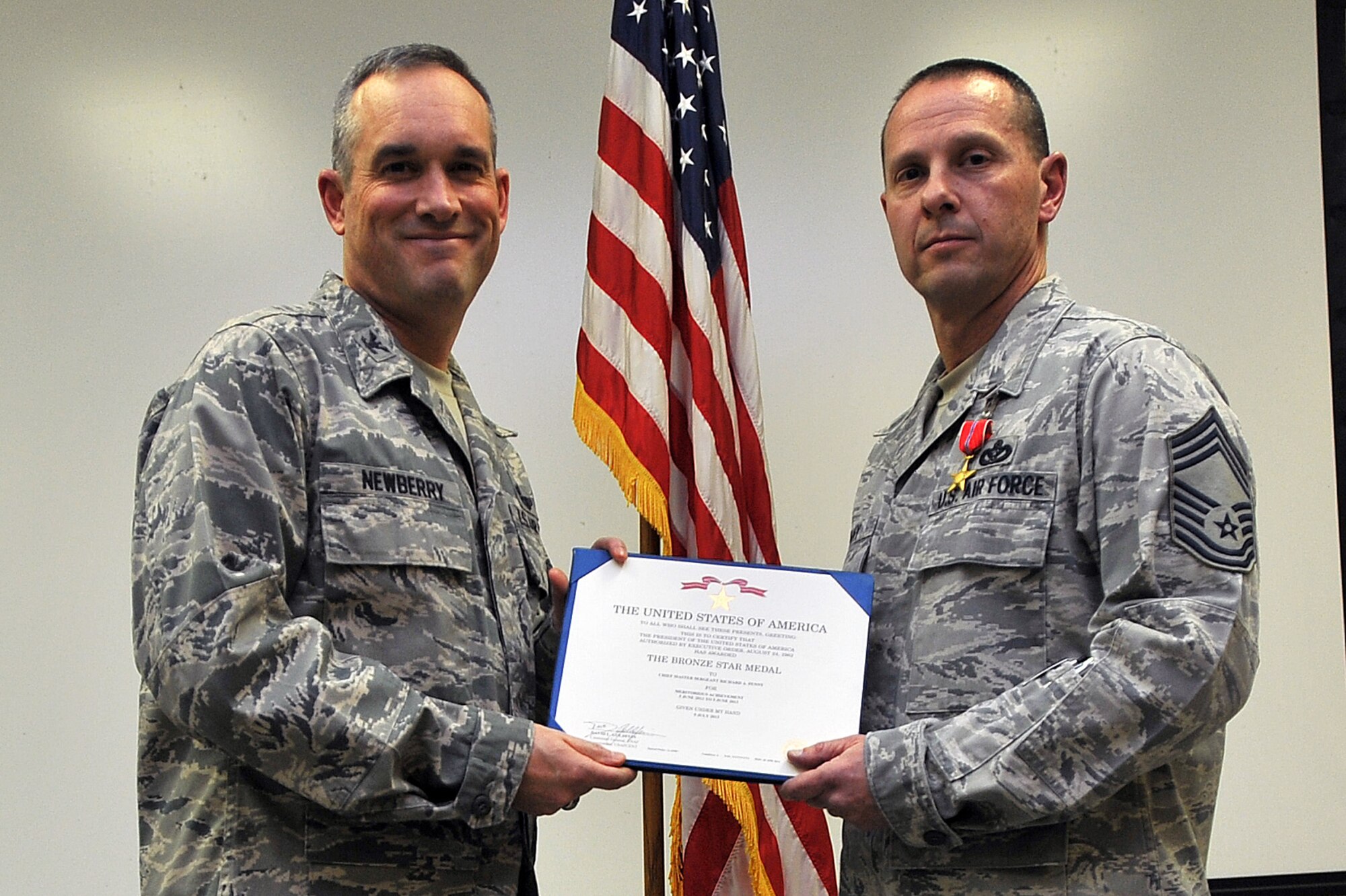 Col. Brian Newberry, 92nd Air Refueling Wing commander, presents the Bronze Star Medal to Chief Master Sgt. Richard Penny Dec. 13, 2013, at Fairchild Air Force Base, Wash. Penny received the honor for his meritorious achievement while he was the 1st Expeditionary Civil Engineer Group chief enlisted manager in Southwest Asia. (U.S. Air Force photo by Staff Sgt. Veronica Montes)