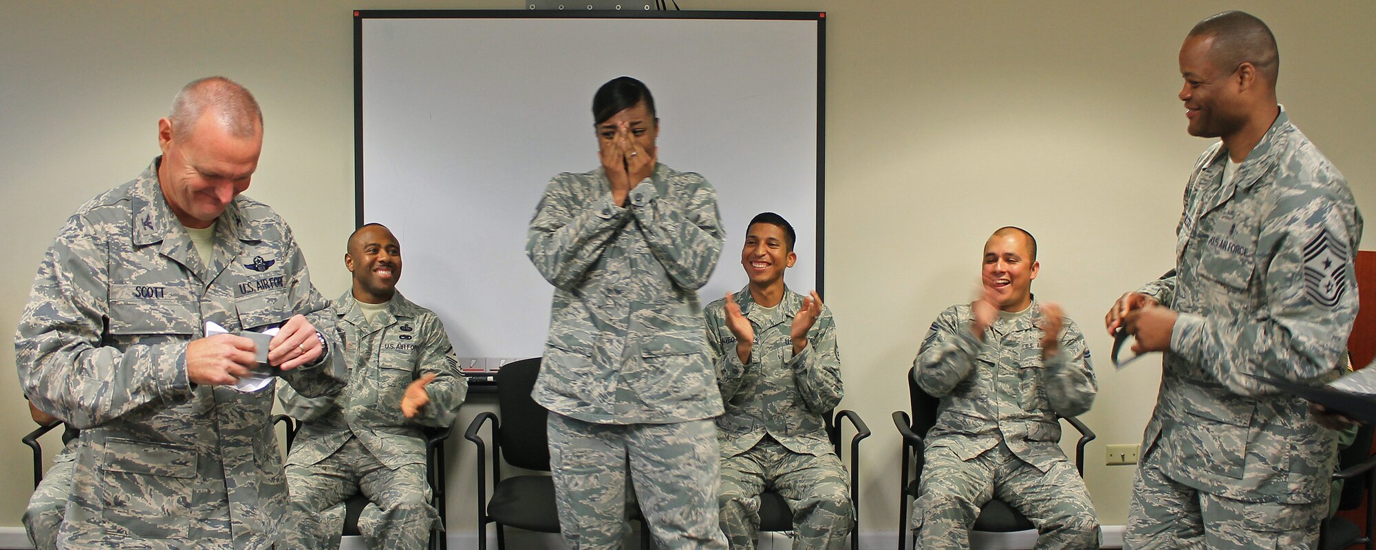 Col. Terry Scott, 15th Wing vice commander, left, and  Chief Master Sgt. Leslie Bramlett, 15th Wing command chief, right,  prepare to tack new technical sergeant stripes on surprised Staff Sgt. Angela Alveo-Forbes, 535th Airlift Squadron, independent duty medical technician, at the Joint Base Pearl Harbor-Hickam First Term Airman Center, Hawaii, Dec. 13. 2013. Alveo-Forbes was instantaneously promoted to the rank of Tech. Sgt. under the Stripes for Exceptional Performers program and recognized for her outstanding contributions to the mission through hard work and determination. (U.S. Air Force photo/Senior Airman Stoltz) 