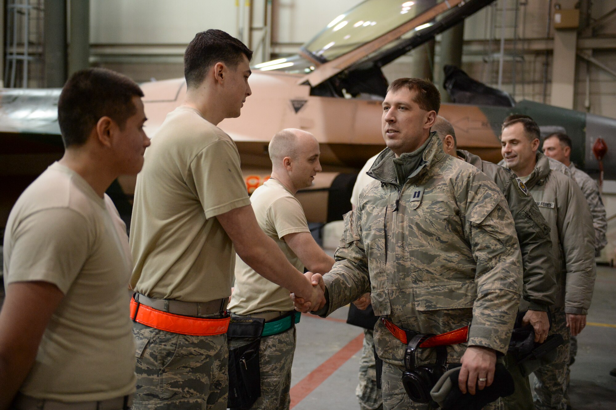 Eielson Icemen shake hands with a weapons load crew from the 354th Aircraft Maintenance Squadron in an aircraft maintenance hangar during an annual load crew competition Dec. 13, 2013, Eielson Air Force Base, Alaska. The event attracted an audience of high ranking officers and senior enlisted members who watched the load crews perform a combat loading sequence on a pair of F-16 Fighting Falcons. (U.S. Air Force photo by Airman 1st Class Peter Reft/Released)