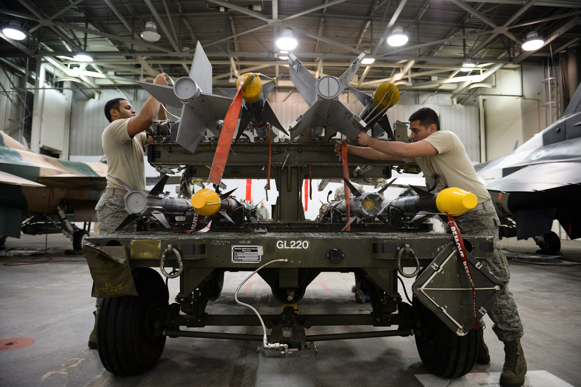 U.S. Air Force Senior Airman Ralphy Rosado and Airman 1st Class Uziel Huerta, 354th Aircraft Maintenance Squadron weapons load crew members, prepare to offload AIM-9 Sidewinder missiles from a 141 munitions trailer in an aircraft maintenance hangar during an annual load crew competition Dec. 13, 2013, Eielson Air Force Base, Alaska. Rosado and Huerta were on opposing load crews competing for Eielson's load crew of the year award. (U.S. Air Force photo by Airman 1st Class Peter Reft/Released)
